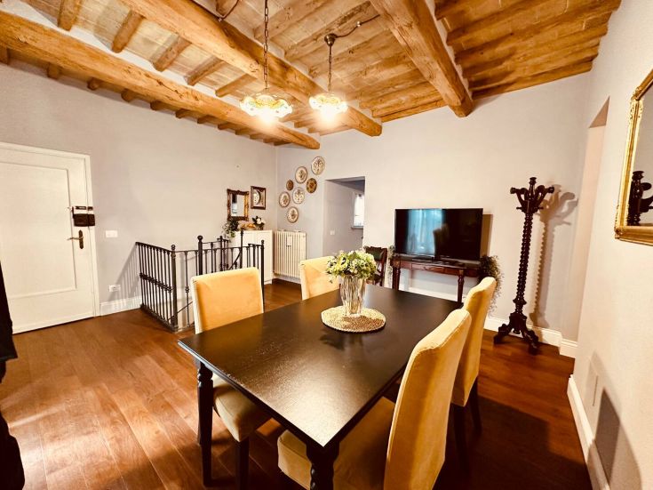 Soggiorno luminoso con tavolo da pranzo in legno e arredi funzionali, perfetto per incontri familiari.