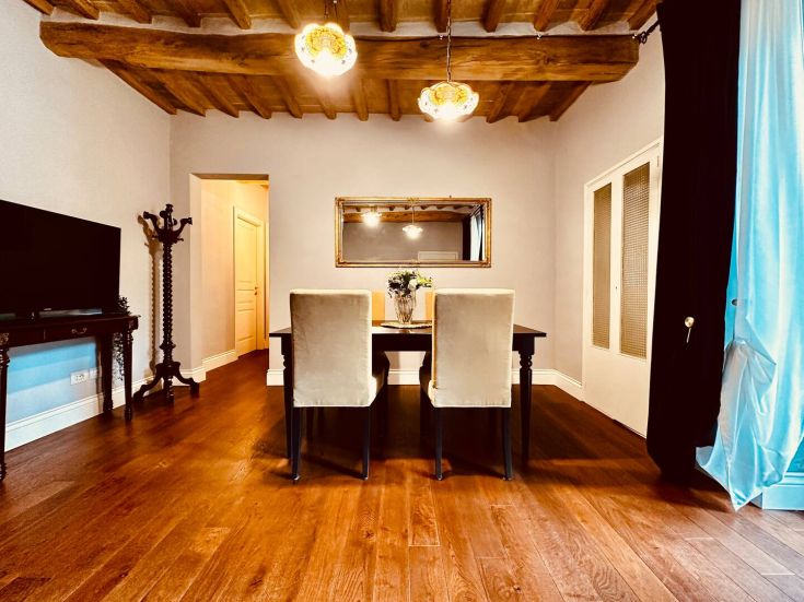 Soggiorno luminoso con un tavolo da pranzo e semplici decorazioni. Spazio ideale per trascorrere momenti di relax.