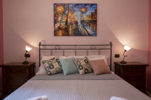 Chambre simple avec un lit double, dotée de meubles modernes et de tons neutres.