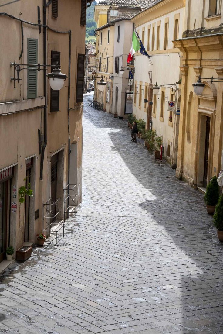Un charmant ruelle pavée à Bevagna, illuminée par des lanternes et entourée de bâtiments historiques.