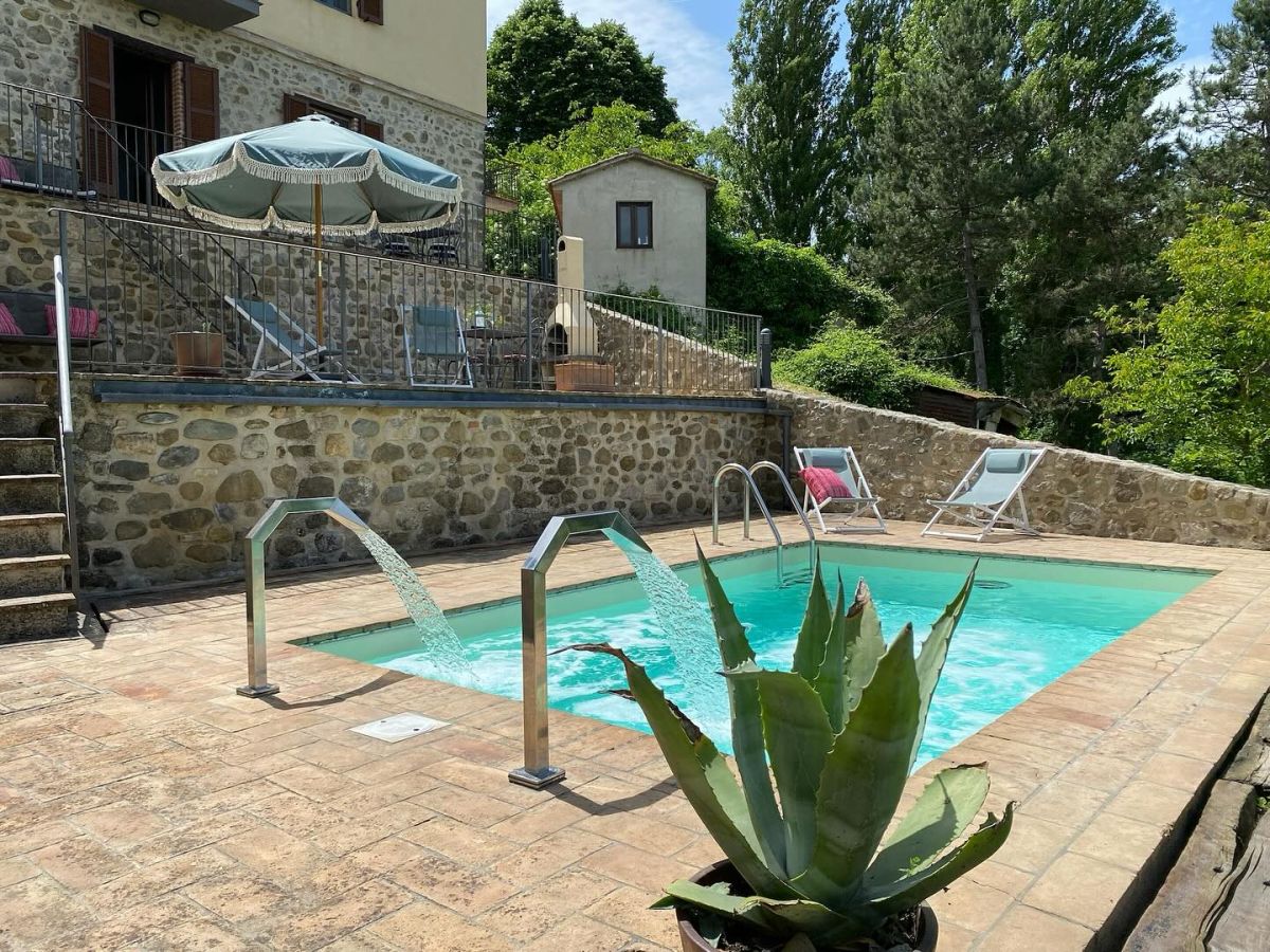 Momenti di tranquillità a bordo di una piscina in un tipico borgo circondato dalla natura umbra.