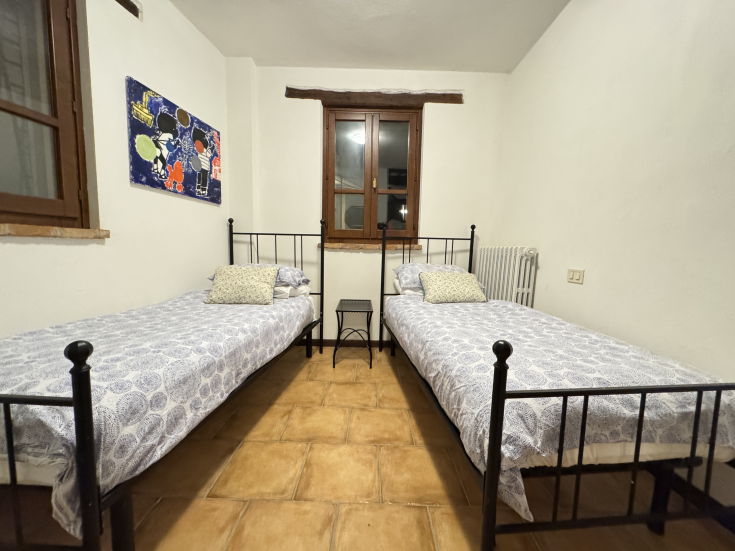 Une chambre avec deux lits simples située dans un village historique tranquille. Idéale pour un séjour relaxant.