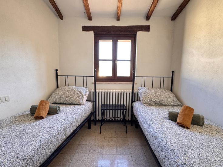 Chambre rustique avec deux lits simples, idéale pour un séjour paisible dans le village de Cattolli di Sotto.