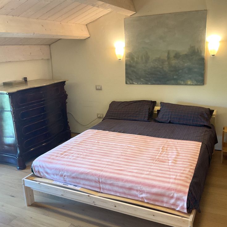 Einfaches Doppelzimmer mit Kleiderschrank und dekorativen Elementen an den Wänden.