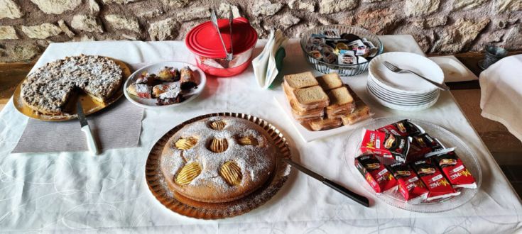Un tavolo apparecchiato con una varietà di dolci e snack adatti per una merenda semplice.