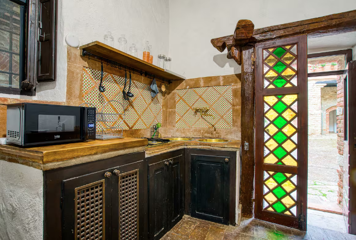 Cozy kitchen with colorful tiles and good natural light, ideal for social moments.