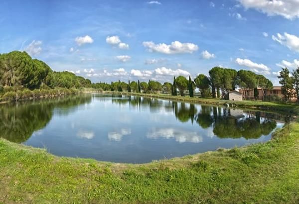 Un agriturismo paisible situé dans une zone verdoyante, entouré d'arbres et de végétation, offrant une atmosphère relaxante.