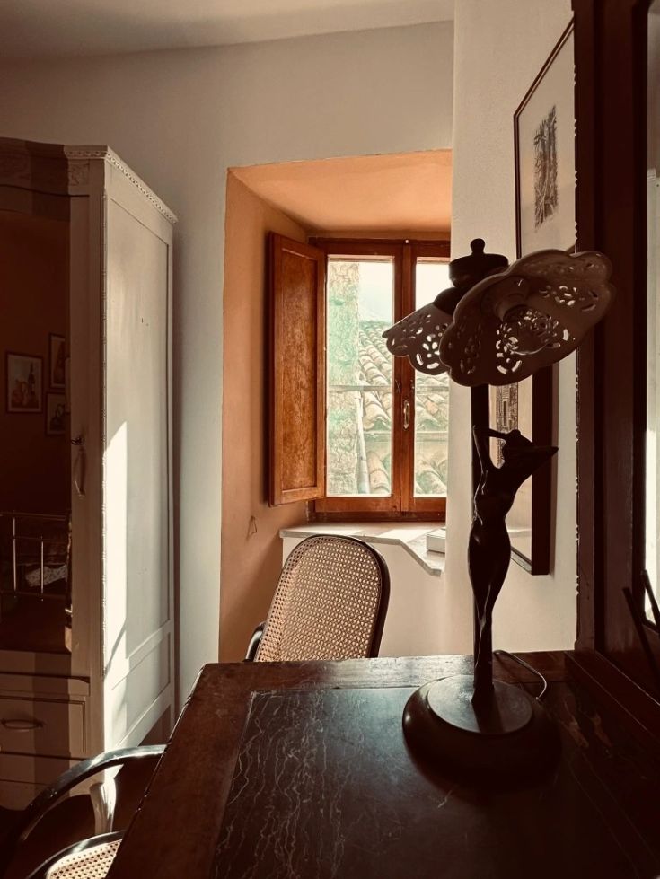 Entspannungsbereich mit natürlichem Licht, einfachem Kronleuchter und Fenstern mit Blick nach draußen.