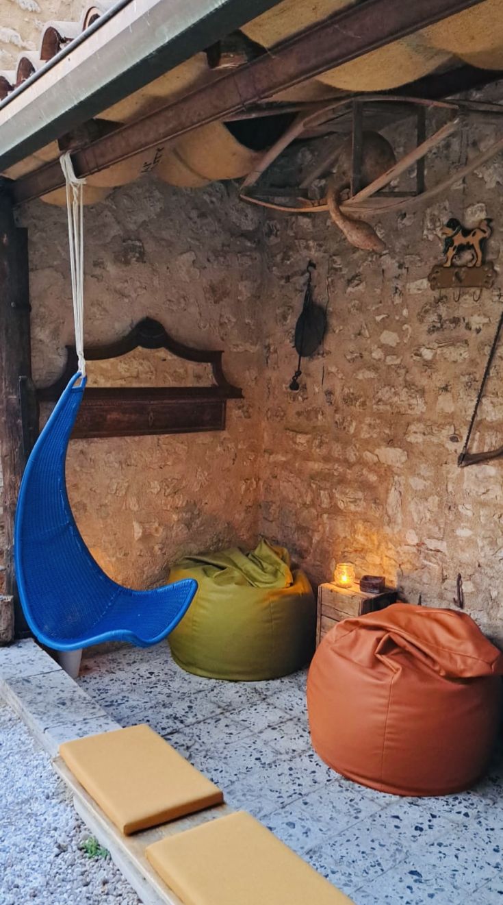 Ein gemütlicher Bereich mit einem hängenden Stuhl und bunten Poufs, perfekt für Entspannungsmomente.