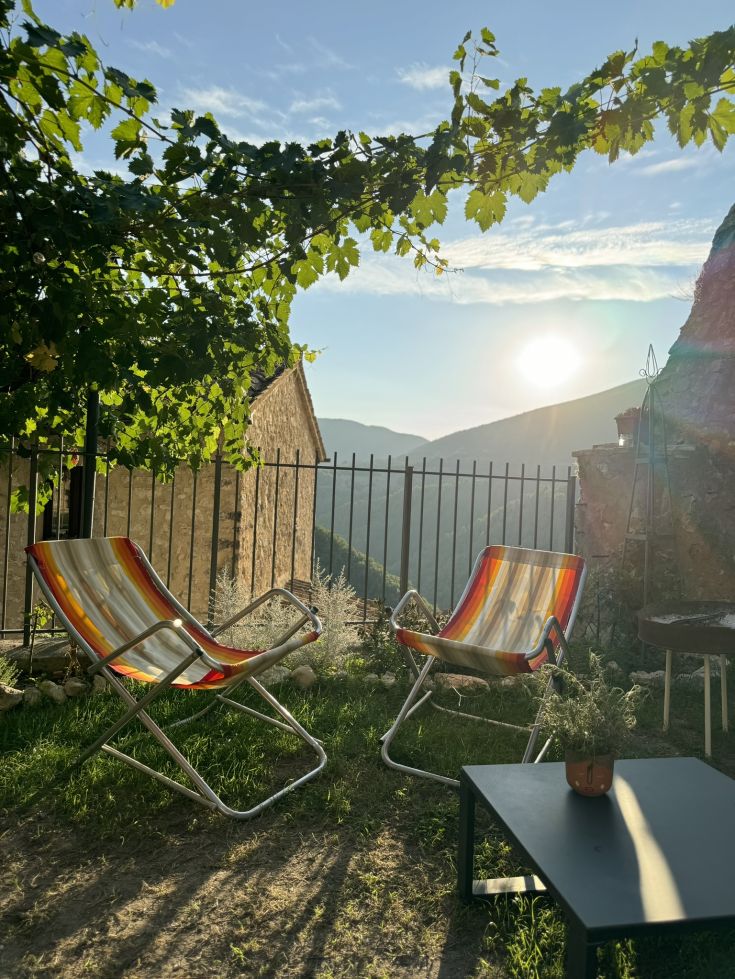 Eine grüne Ecke mit Liegestühlen, perfekt zum Entspannen und den Sonnenuntergang zu genießen.