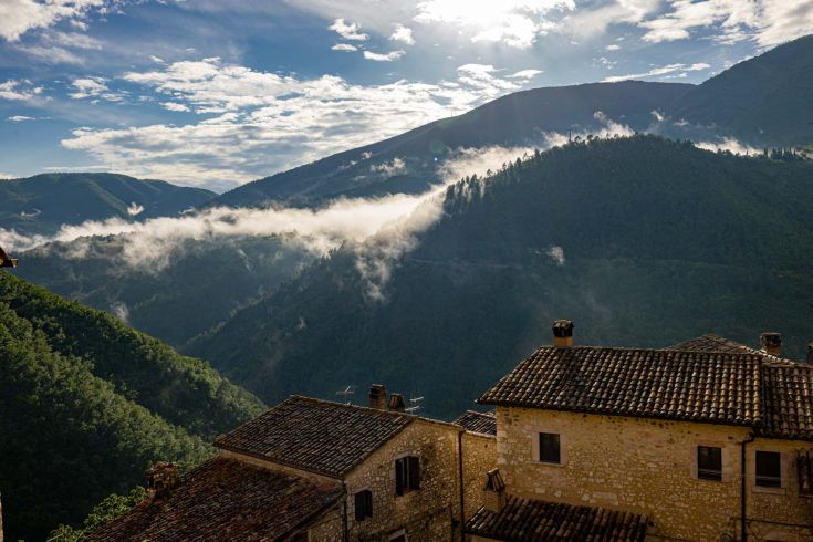 Eine Berglandschaft mit grünen Hügeln und Wolken am Himmel. Ein friedliches Bild der Natur.
