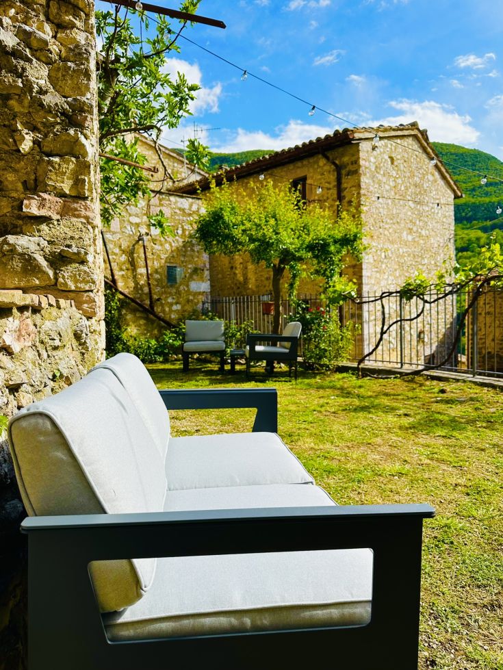 Ein ruhiger Bereich in einem historischen Dorf mit einem grünen Garten, der zum Entspannen einlädt.