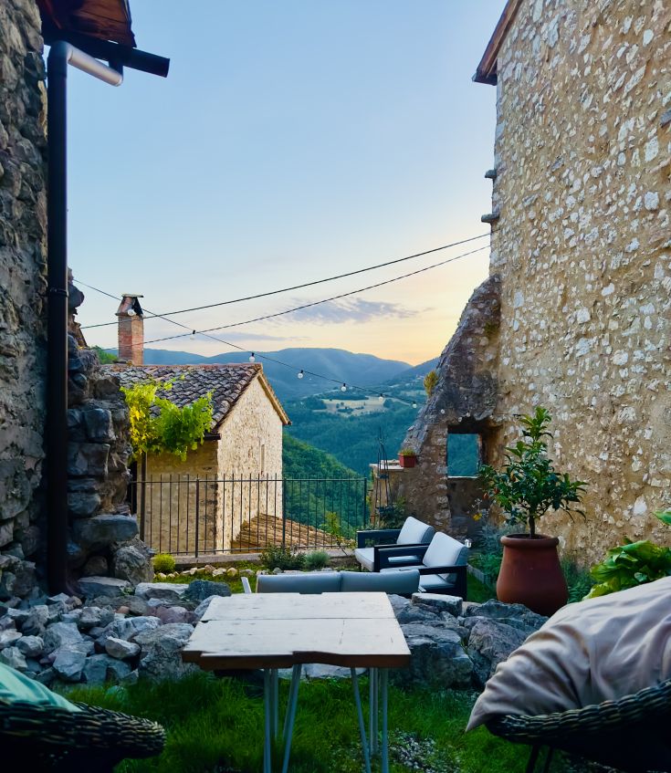 Eine ruhige Szene eines versteckten Gartens, umgeben von historischen Mauern, perfekt zum Entspannen und Genießen der umbrischen Landschaften.