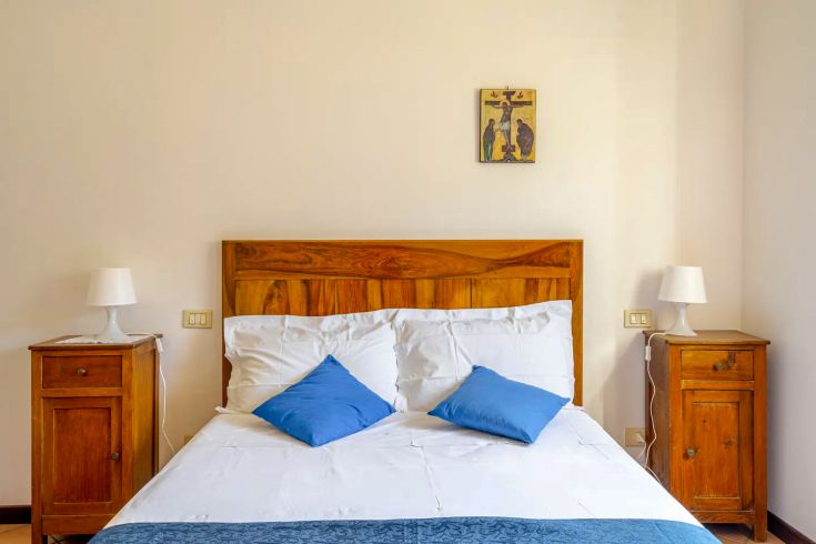 Simple space with a double bed, wooden nightstands, and practical furniture.