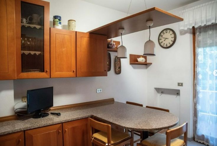 Cucina accogliente con mobili in legno chiaro e accessori curati, ideale per incontri e pasti condivisi.