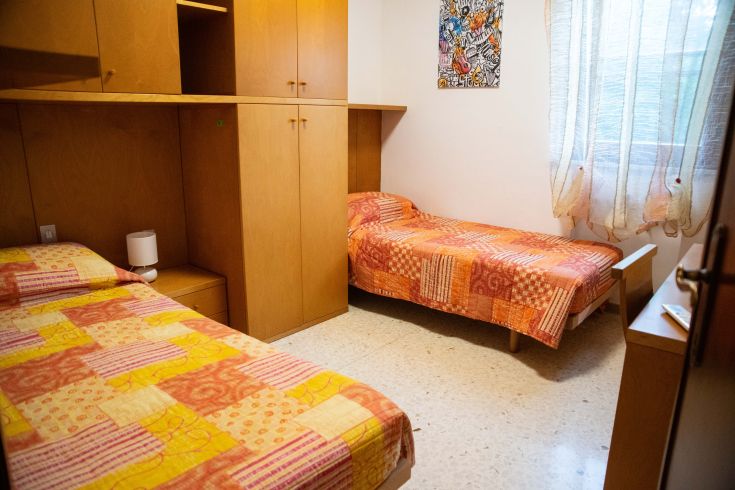 Spazio confortevole con letti singoli, arredato in legno e con alcuni dettagli decorativi.