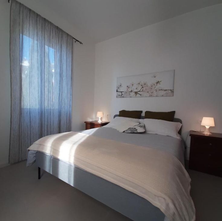 Ein geräumiges und helles Zimmer, einfach eingerichtet, mit zwei Einzelbetten und einem Fenster, das Tageslicht bietet. Ideal für einen komfortablen Aufenthalt.