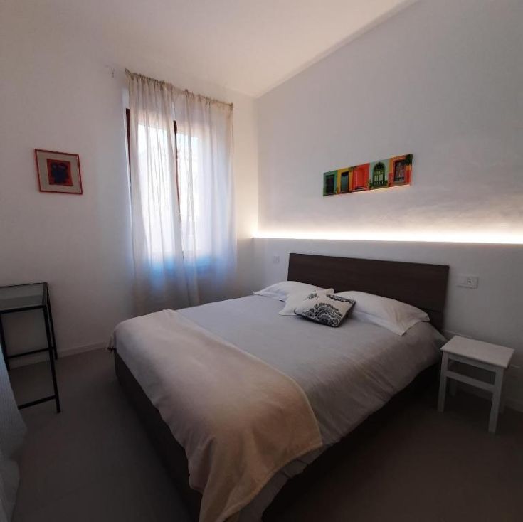 Geräumiges Zimmer mit natürlichem Licht, ausgestattet mit einem Queensize-Bett und einfacher Dekoration. Ideal zum Entspannen.