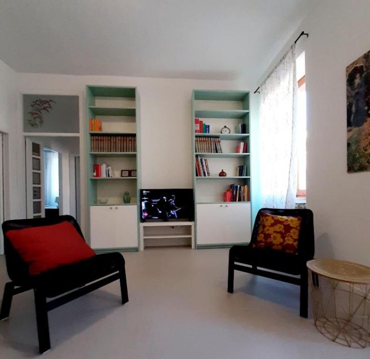 Gemütliches Wohnzimmer einer gut beleuchteten Wohnung mit einfachen dekorativen Elementen, ideal zum Entspannen.