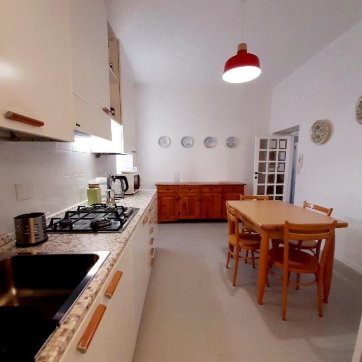 Geräumige und helle Küche mit Holzmöbeln und zeitgemäßem Zubehör.