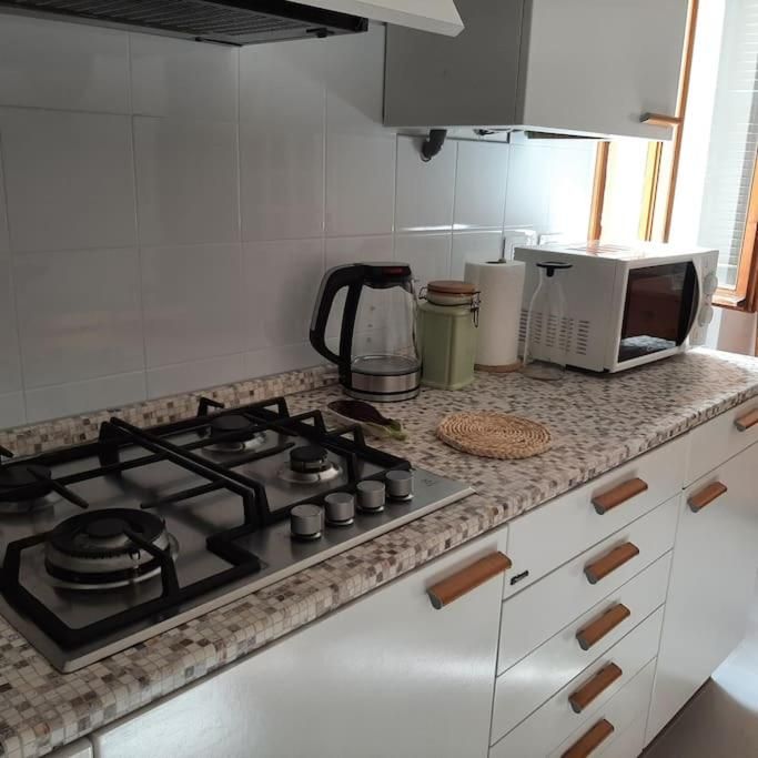 Helle und funktionale Küche mit Kochfeld, modernen Geräten und einladenden Details.