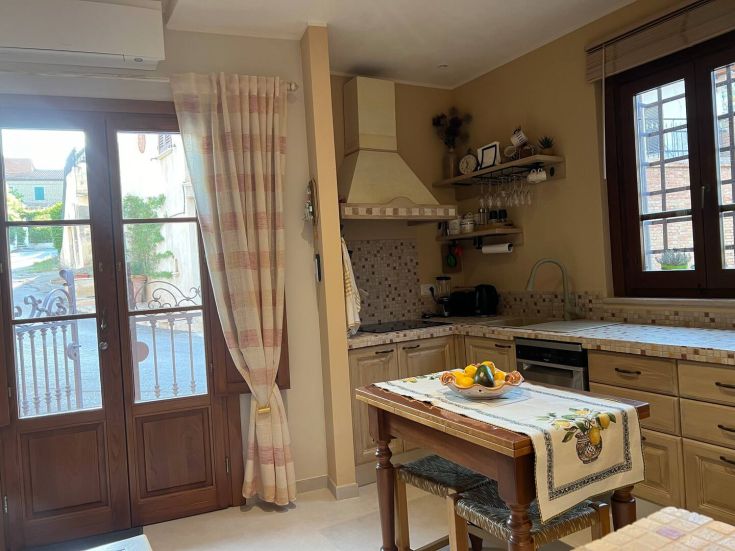 Spacious and well-lit kitchen with rustic furnishings and views of the surrounding countryside.