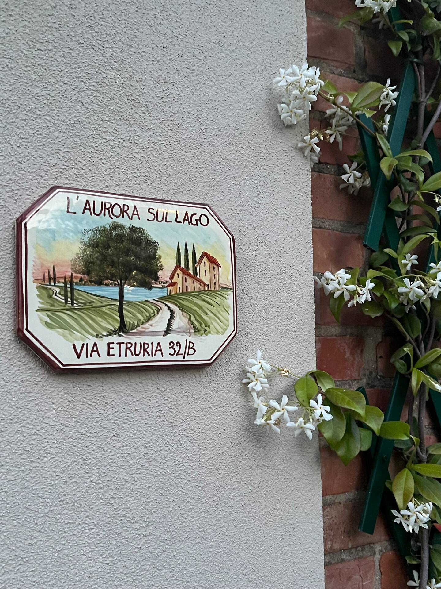 Decorazione che rappresenta L'Aurora sul Lago, con fiori bianchi attorno, perfetta per un momento di relax in natura.