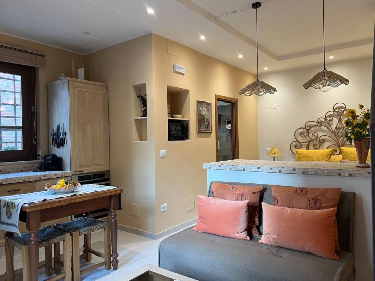 A simple and cozy kitchen-living area featuring modern elements and functional furniture.