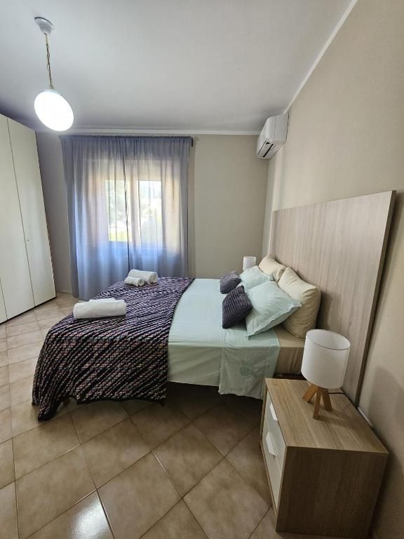 Geräumiges und gut beleuchtetes Schlafzimmer mit bequemen Betten und einfachen Möbeln.