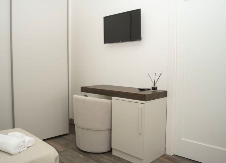Chambre simple avec télévision et coin bureau. Espace calme pour un séjour agréable.