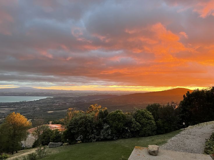 A sunset over the Umbrian countryside, where warm colors illuminate the rural landscape.