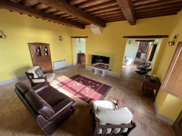 A spacious and bright living room in a typical Umbrian farmhouse, simply furnished and surrounded by nature.