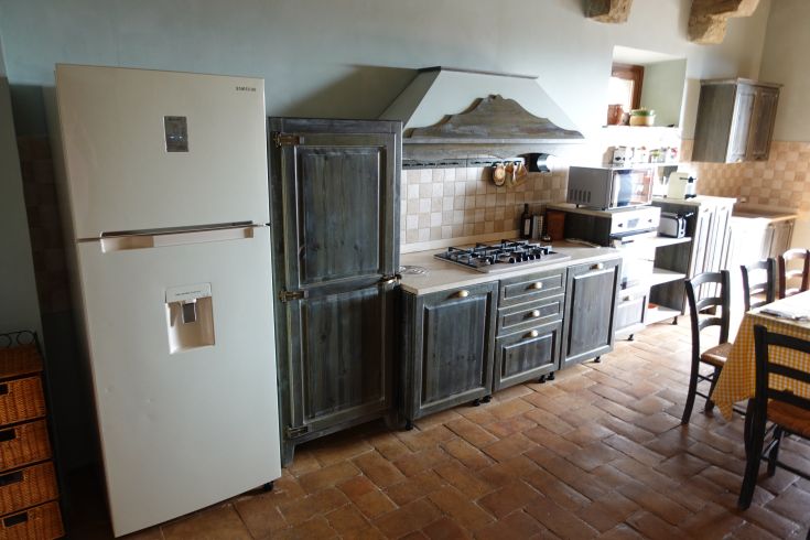 Rustic kitchen with wooden furniture and modern appliances, designed for family gatherings.