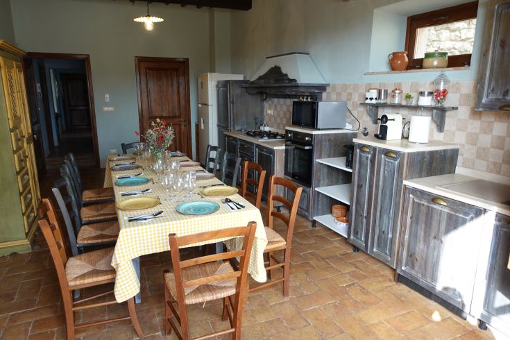 Warm and welcoming kitchen of Villa Gosparini, featuring a set table for a shared meal.