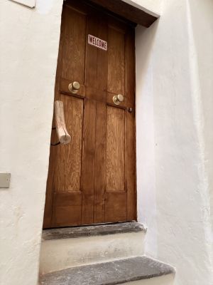 Porta in legno con una scritta accogliente, che invita a entrare in un ambiente sereno e ospitale.