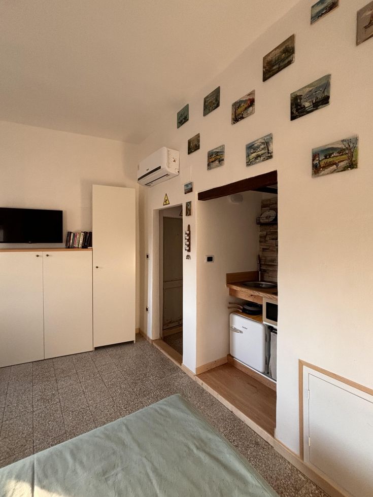 Interno di una casa con cucina moderna e arredi semplici.