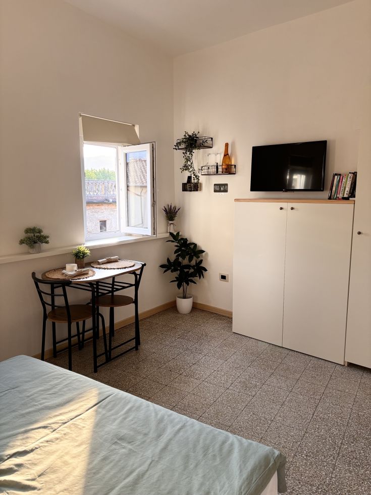 Una camera luminosa e accogliente con arredi semplici e moderni, perfetta per momenti di relax.