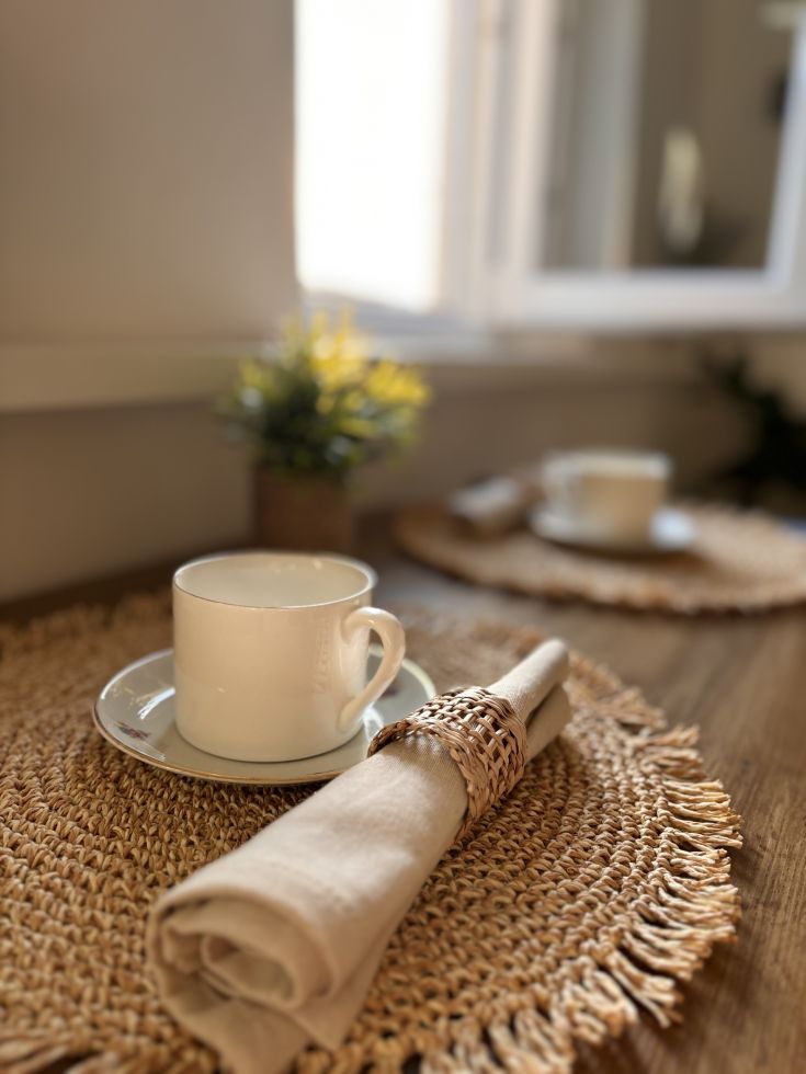 Un tavolo sistemato con una tazza e un tovagliolo, perfetto per una pausa tranquilla.