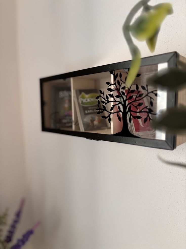 Una bacheca in legno, decorata con incisioni, contenente diversi oggetti di uso comune.