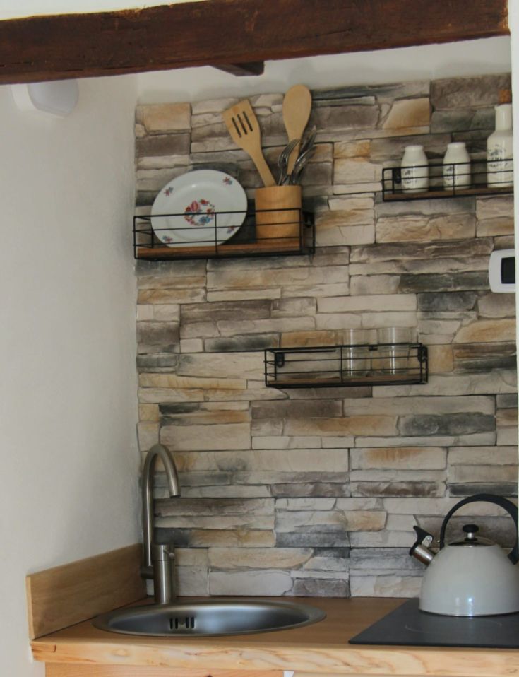 Cucina funzionale con utensili e stoviglie disposti in ordine su ripiani.