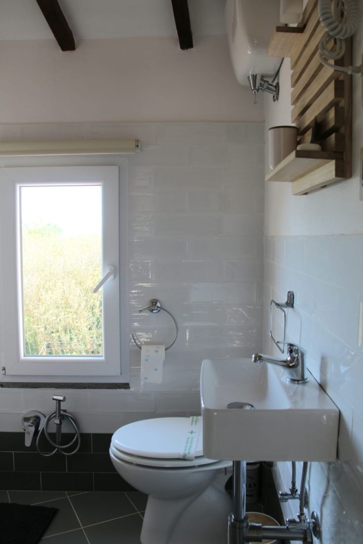 Bagno contemporaneo dall'aspetto semplice, con luce naturale che filtra da una finestra.