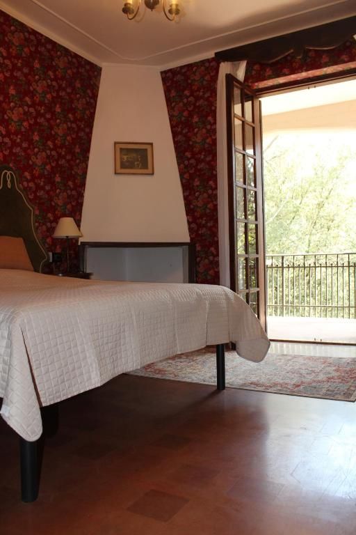 Chambre dans une villa avec accès à une terrasse et vue sur la nature environnante.