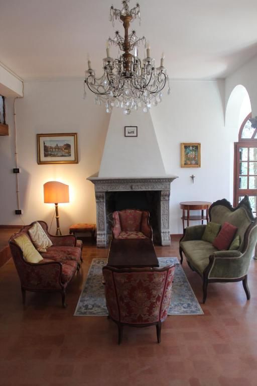 Un salon accueillant avec une cheminée, meublé simplement avec des fauteuils et une lampe, offrant une ambiance confortable.