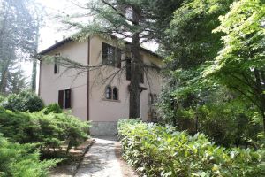 Villa spacieuse entourée d'un jardin bien entretenu, avec vue sur les collines environnantes.