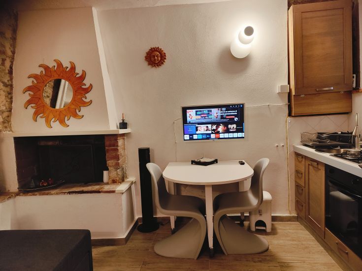 Simple interior of an apartment with a kitchen and dining area, furnished practically with a fireplace.