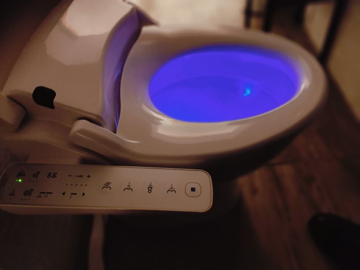 A modern toilet with blue lighting, integrating functionality and contemporary design.