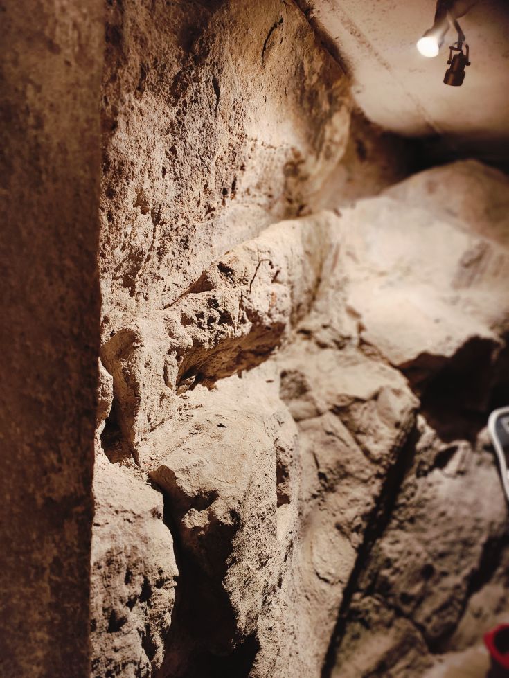 Rock wall illuminated in a natural area, showcasing its geological features.
