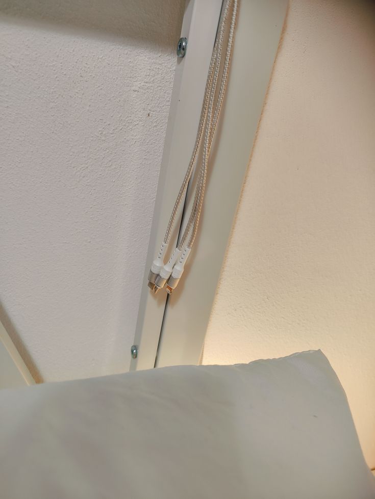 Detail of organized cables emerging from a white building.