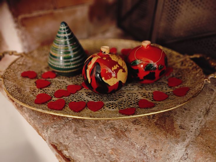 Christmas decorations on a tray, featuring red felt hearts and various other decorative elements.