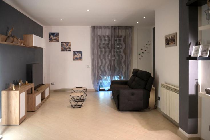 Un'accogliente zona soggiorno con un divano, mobili in legno e alcuni elementi decorativi.